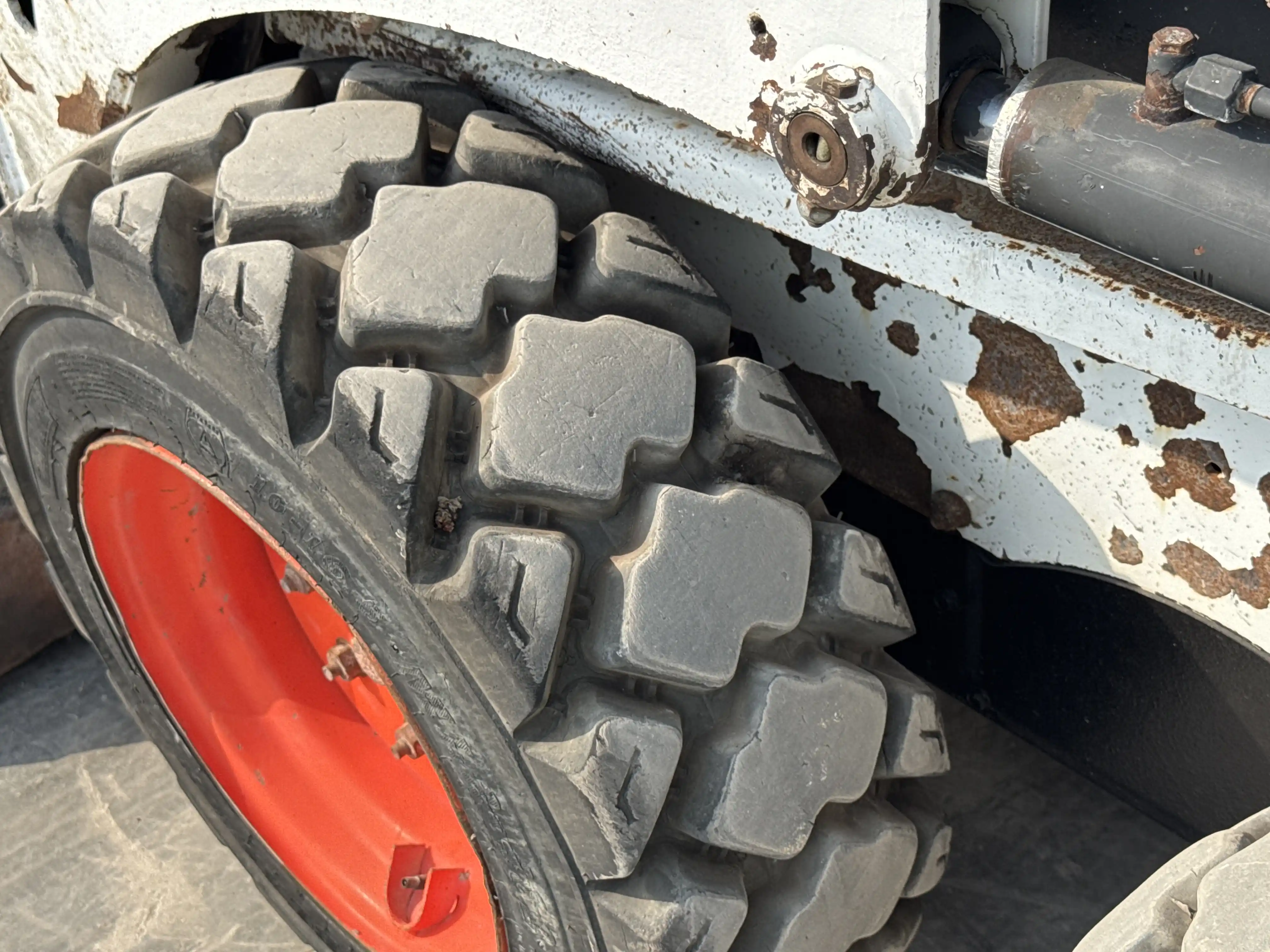 SSL-010-Bobcat-S450-skid-steer-loader-inspection-chassis-left-front-tire-wheel-hub-condition