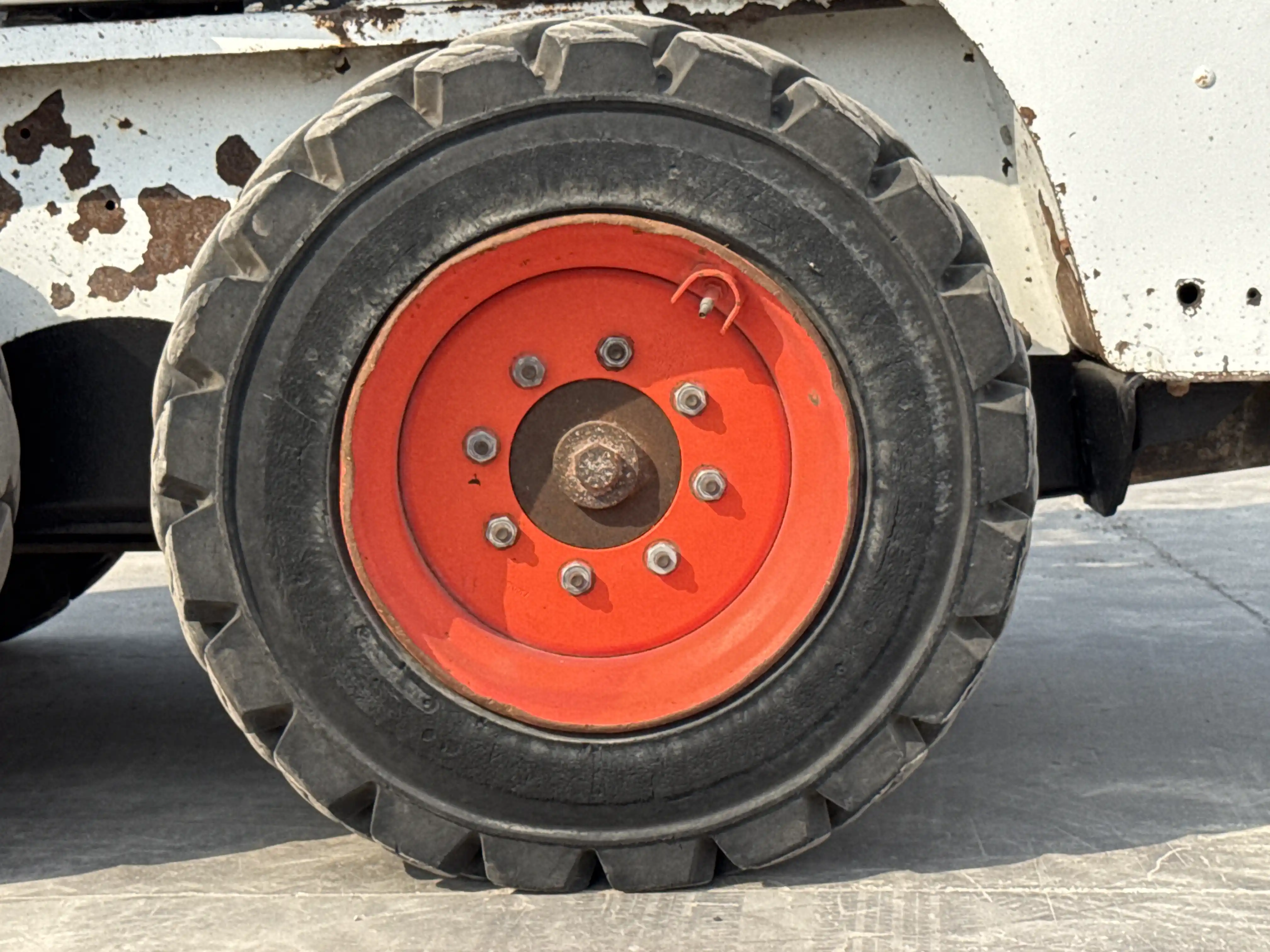 SSL-010-Bobcat-S450-skid-steer-loader-inspection-chassis-left-rear-tire-wheel-hub-condition