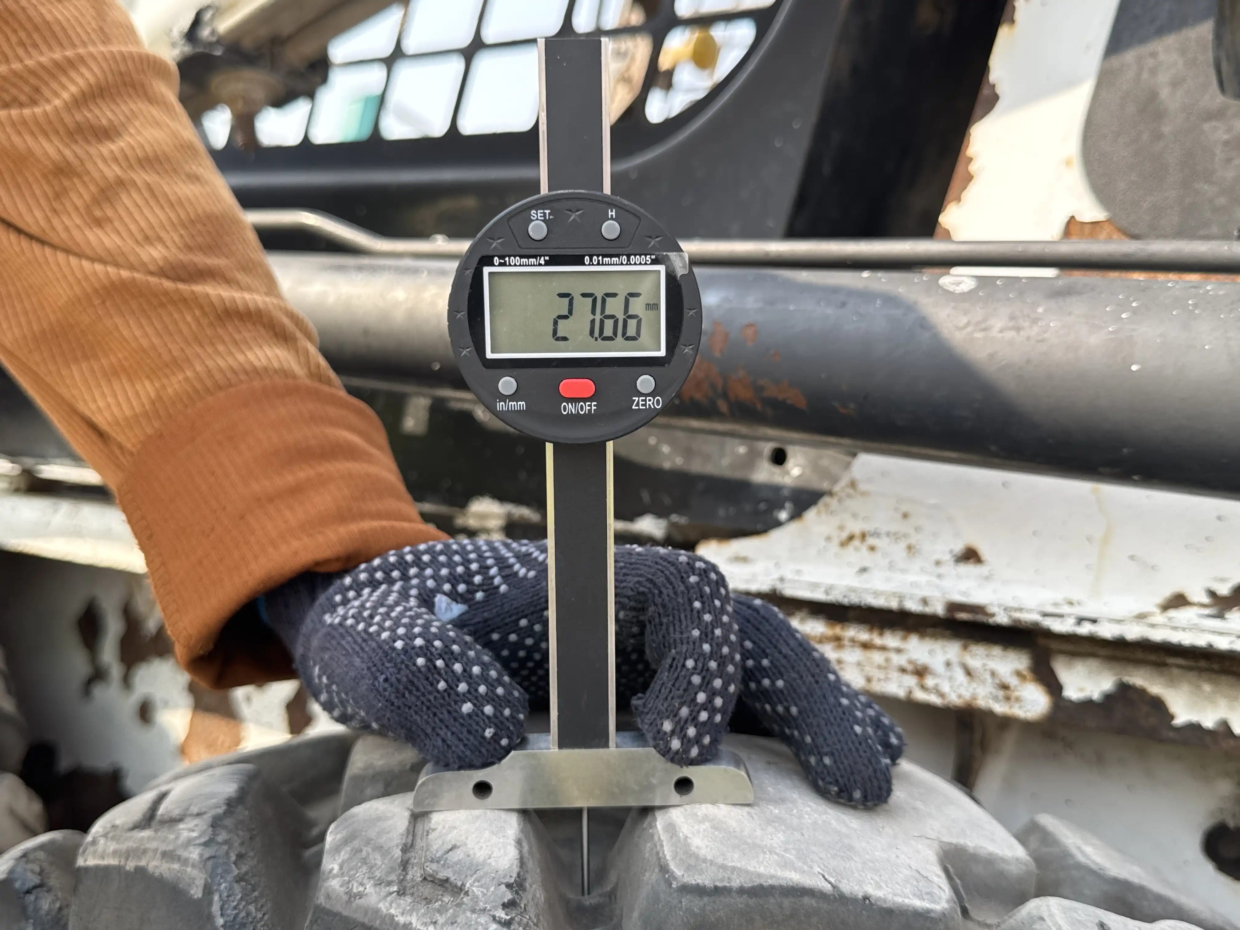 SSL-010-Bobcat-S450-skid-steer-loader-inspection-chassis-left-rear-tire-tread-depth
