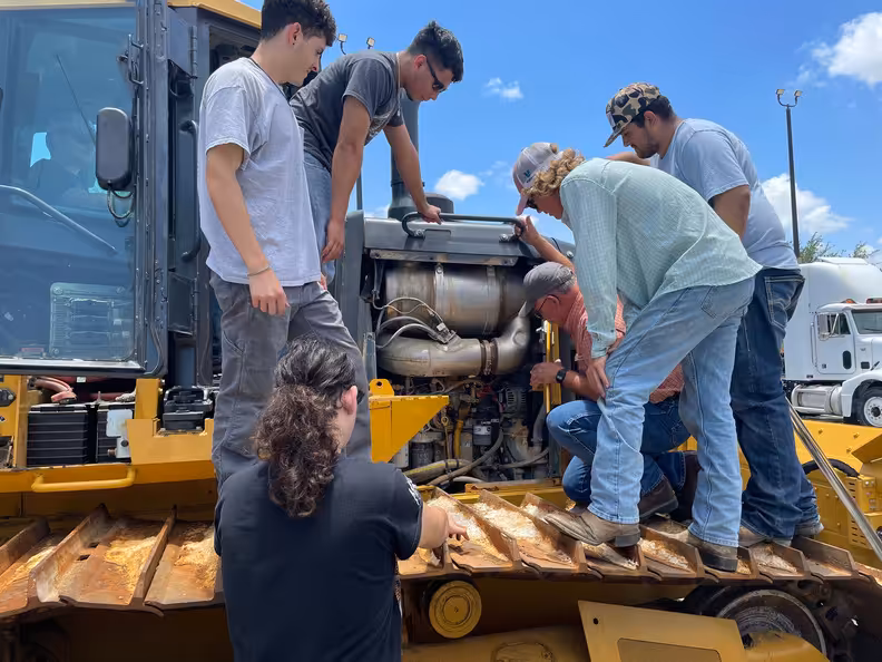 عمال يقومون بإجراء صيانة لآلية ثقيلة.